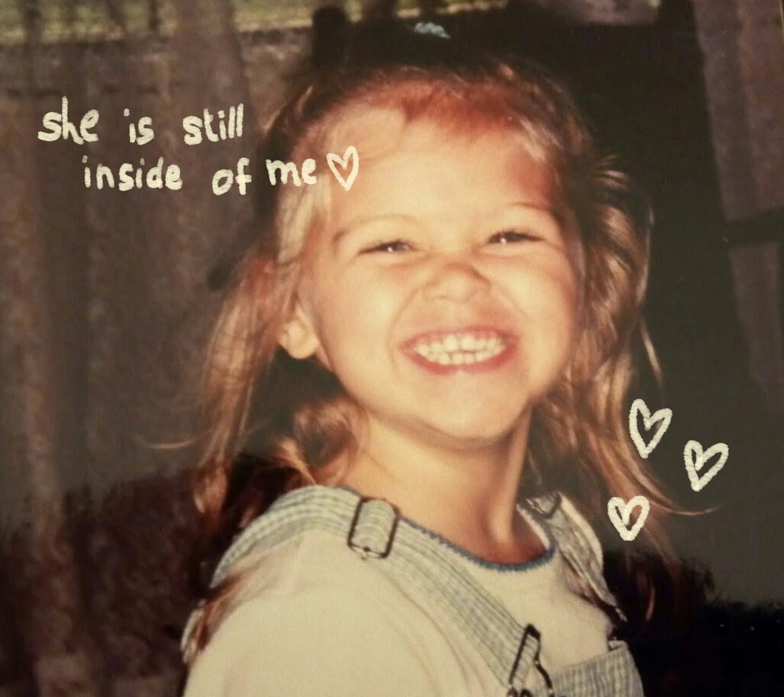 A young girl with a big smile and hearts.