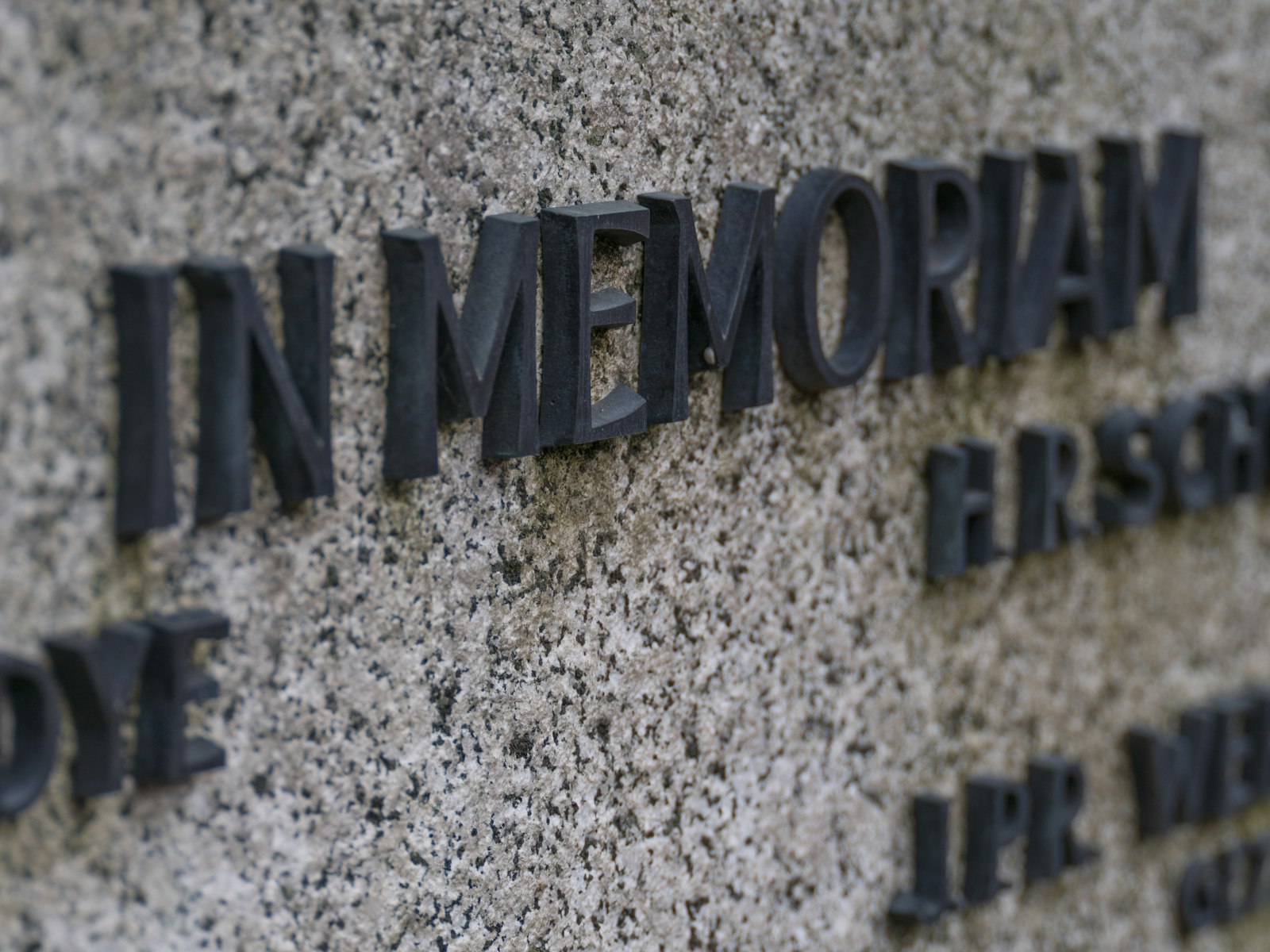 In memoriam text on a granite memorial wall.